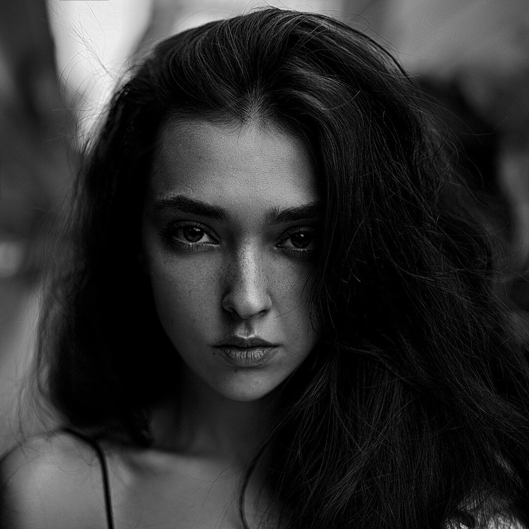 Professional portrait of a young woman with dark hair and confident expression