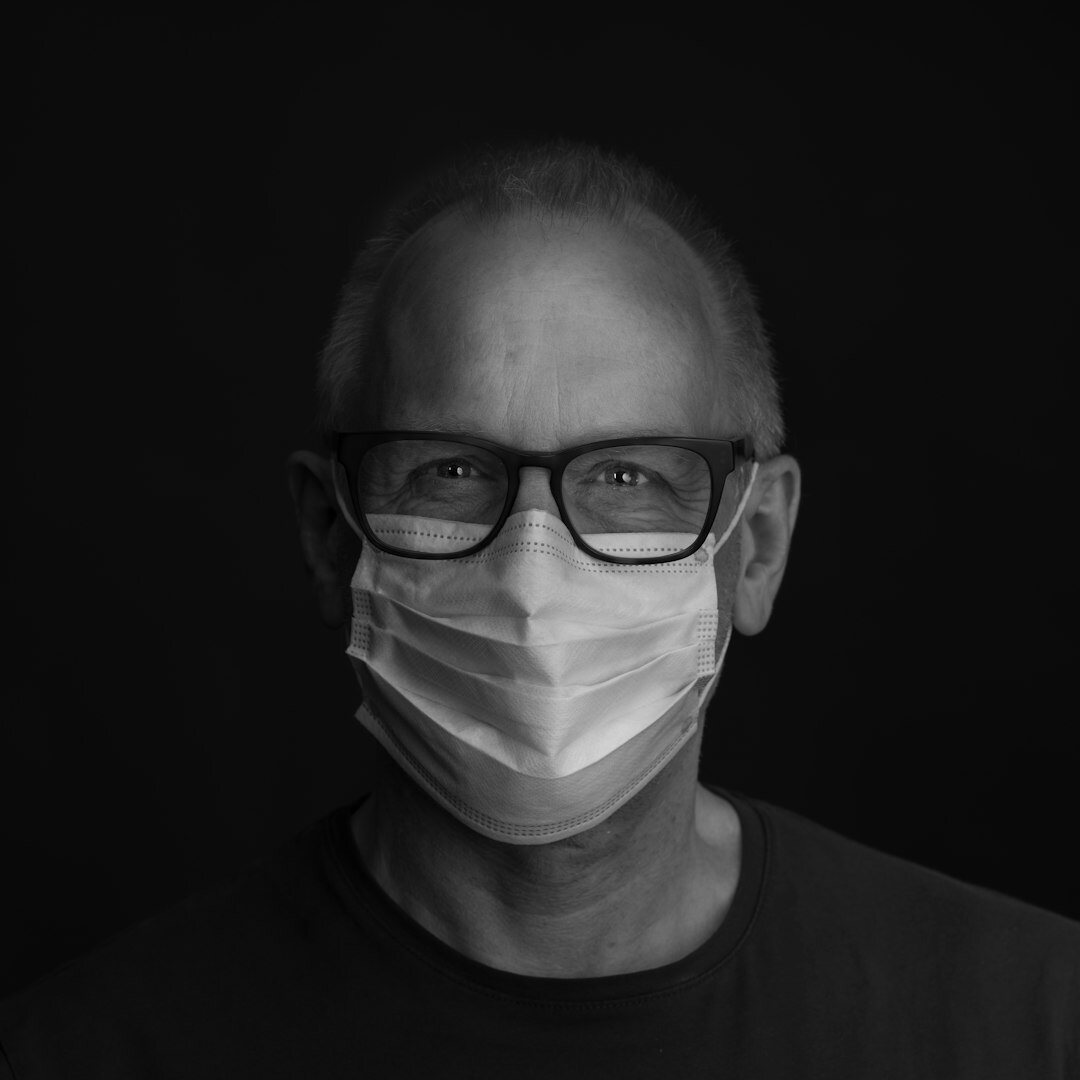 Professional portrait of a man in his 40s with glasses and suit