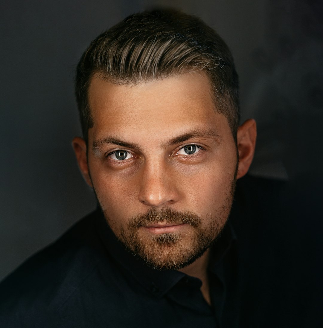 Professional portrait of a middle-aged man with light stubble in business casual