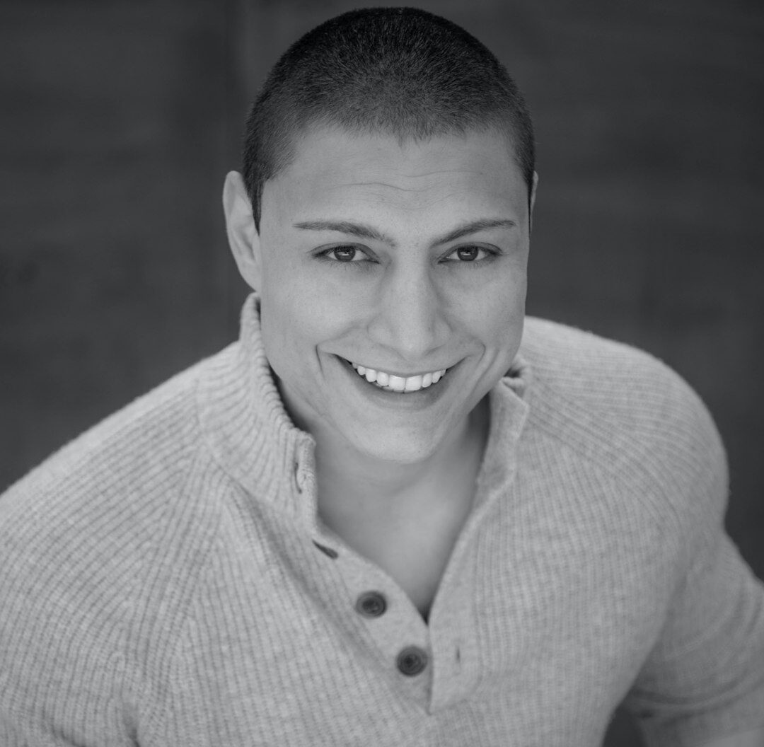Professional portrait of a young man in his 30s smiling in casual business attire